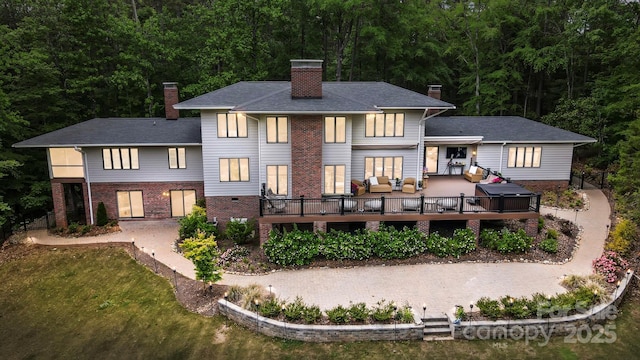 115 Forestcliff Ct NE, Concord, NC 28025 - back of house featuring a chimney, outdoor lounge area, a wooden deck, brick siding, and a wooded view