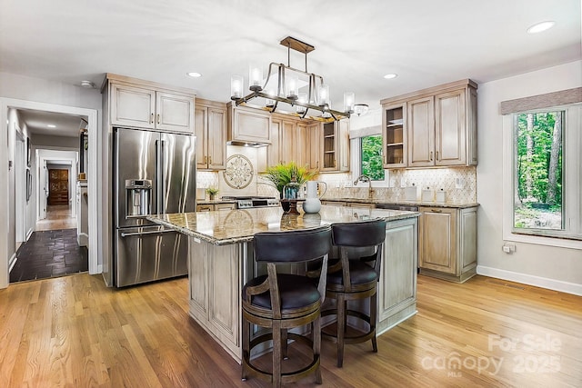 115 Forestcliff Ct NE, Concord, NC 28025 - kitchen featuring stainless steel refrigerator with ice dispenser, light stone counters, tasteful backsplash, a center island, and recessed lighting