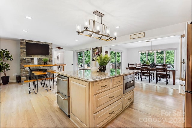 115 Forestcliff Ct NE, Concord, NC 28025 - kitchen with healthy amount of natural light, light brown cabinets, light wood-style floors, light stone countertops, and recessed lighting