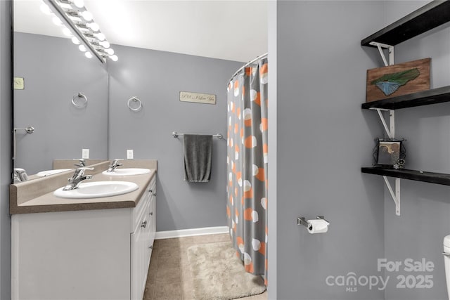 full bath with double vanity, a sink, a shower with shower curtain, and toilet