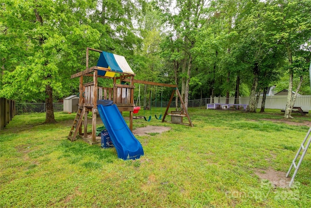 view of play area featuring a fenced backyard, an outdoor structure, a lawn, and a storage shed