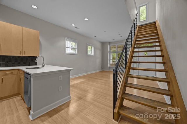 625 N Alexander St, Charlotte, NC 28202 - kitchen with a sink, dishwashing machine, a peninsula, baseboards, and decorative backsplash