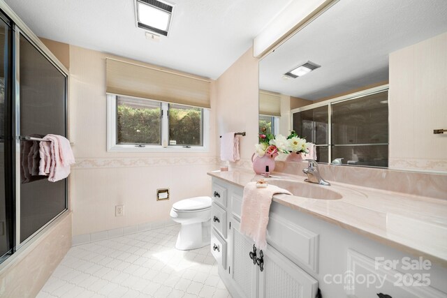 1152 Bent Tree Dr Unit F2Garage, Hendersonville, NC 28739 - bathroom with toilet, vanity, wainscoting, and combined bath / shower with glass door