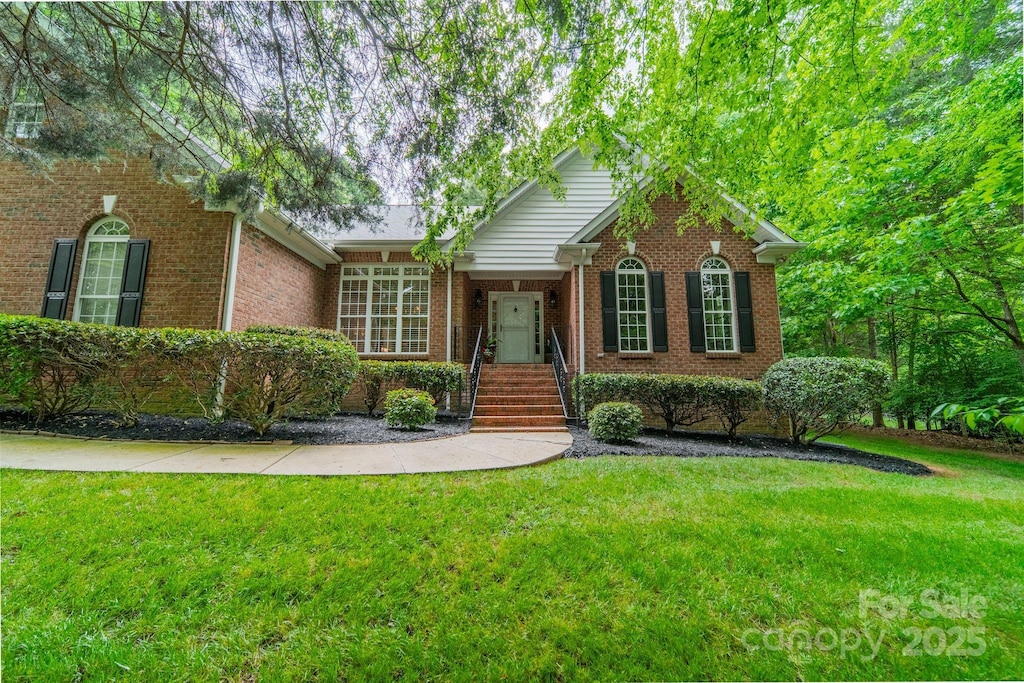 ranch-style house with brick siding and a front lawn