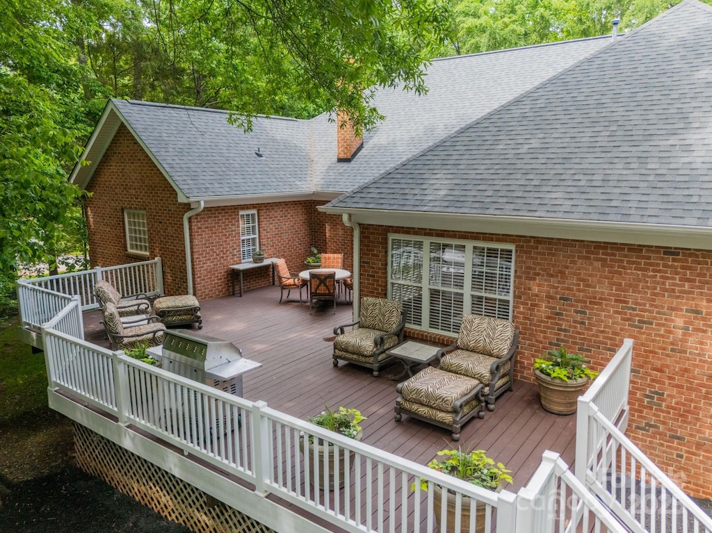 wooden deck with outdoor dining space and an outdoor hangout area