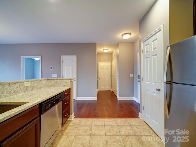 1000 E Woodlawn Rd Unit 402, Charlotte, NC 28209 - kitchen with light tile patterned flooring, light stone countertops, appliances with stainless steel finishes, and baseboards