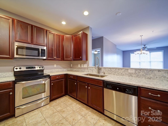 1000 E Woodlawn Rd Unit 402, Charlotte, NC 28209 - kitchen featuring appliances with stainless steel finishes, a sink, light stone counters, an inviting chandelier, and light tile patterned flooring