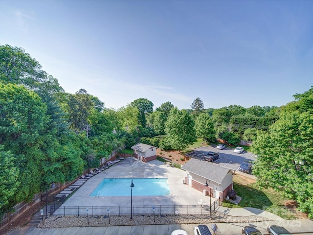 1000 E Woodlawn Rd Unit 402, Charlotte, NC 28209 - exterior space featuring a patio, a fenced backyard, a view of trees, and a fenced in pool