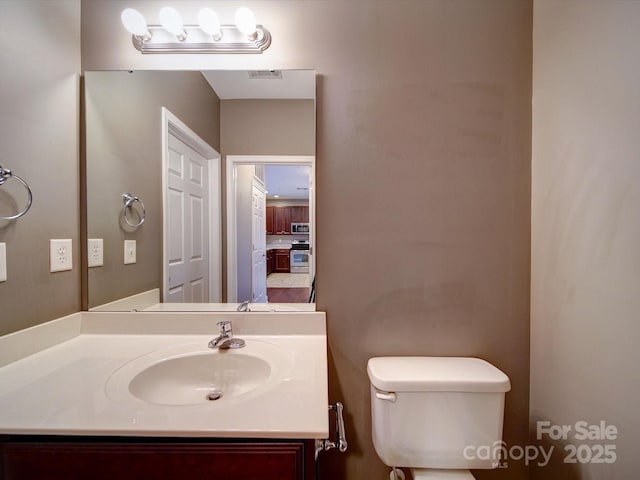 1000 E Woodlawn Rd Unit 402, Charlotte, NC 28209 - half bathroom featuring visible vents, toilet, and vanity