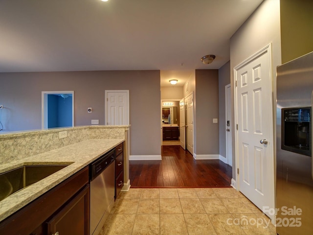 1000 E Woodlawn Rd Unit 402, Charlotte, NC 28209 - kitchen featuring stainless steel appliances, light stone countertops, light wood-style flooring, and dark brown cabinets