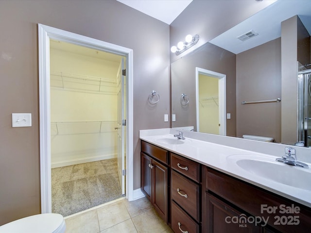 1000 E Woodlawn Rd Unit 402, Charlotte, NC 28209 - full bath featuring double vanity, a walk in closet, tile patterned floors, and an enclosed shower