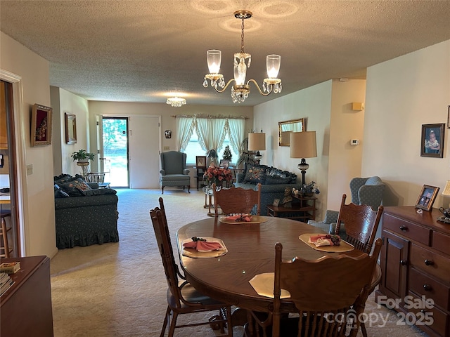 dining room featuring carpet flooring, a notable chandelier, and a textured ceiling