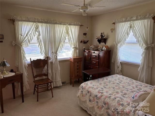 bedroom with a ceiling fan, multiple windows, light carpet, and a textured ceiling