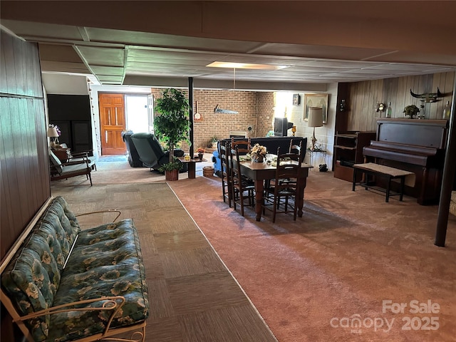 carpeted dining area with wood walls