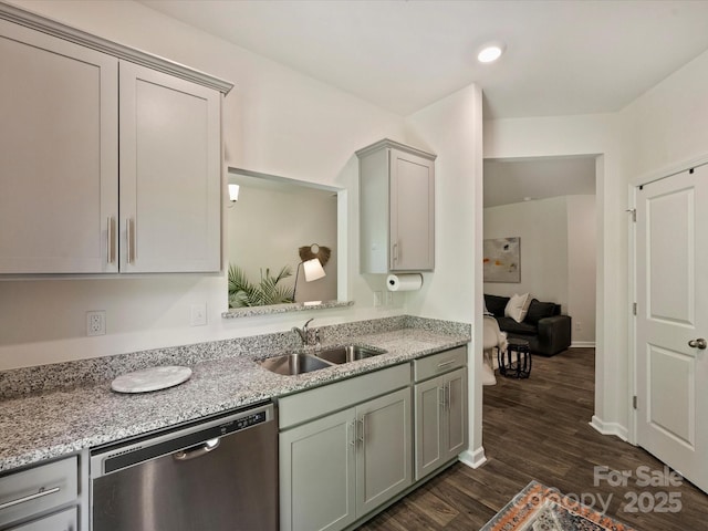 kitchen featuring light stone countertops, dishwasher, a sink, gray cabinetry, and dark wood-type flooring