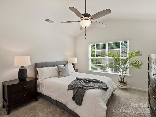 bedroom with carpet floors, a ceiling fan, baseboards, vaulted ceiling, and visible vents