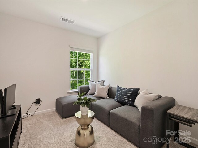 carpeted living room featuring visible vents and baseboards
