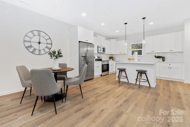dining space featuring recessed lighting, visible vents, and light wood-style flooring