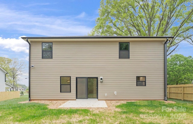 rear view of house with a yard, a patio, and fence