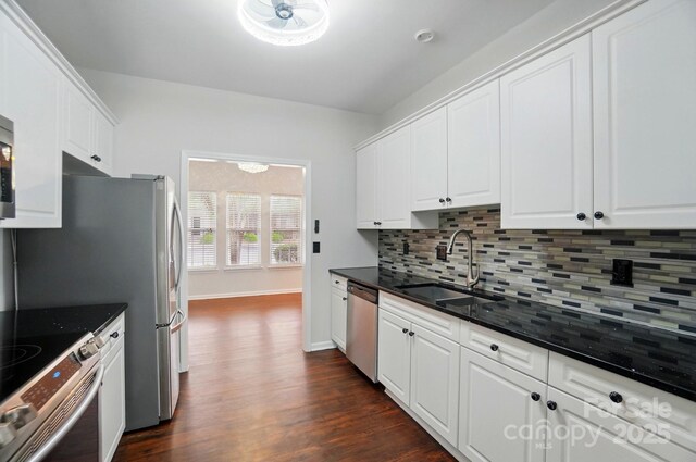 kitchen with a sink, backsplash, stainless steel appliances, and white cabinetry