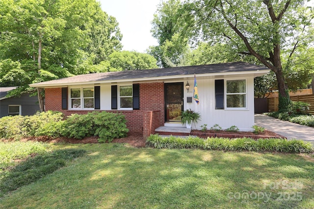 ranch-style home featuring fence, brick siding, and a front yard