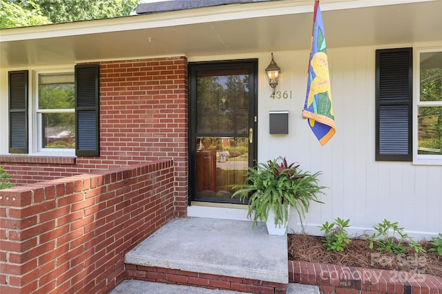 entrance to property with brick siding and covered porch
