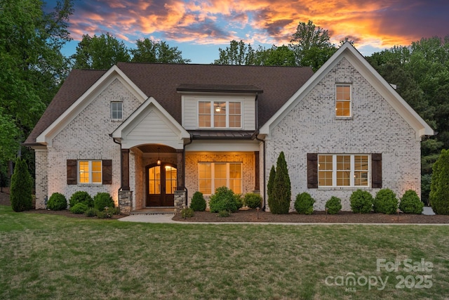 craftsman house with a lawn, roof with shingles, and brick siding