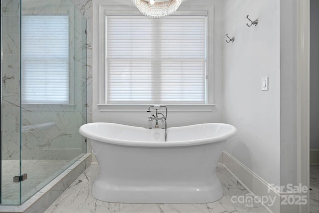bathroom with baseboards, a freestanding tub, a marble finish shower, and marble finish floor