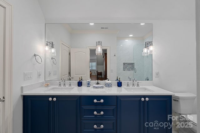 full bath with tiled shower, toilet, double vanity, and a sink