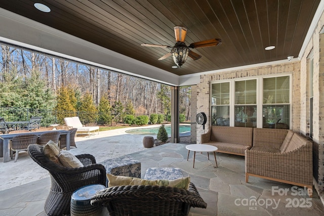view of patio with an outdoor hangout area, a ceiling fan, an outdoor pool, and fence