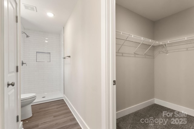 438 Forest Lake Rd, Forest City, NC 28043 - bathroom with visible vents, toilet, baseboards, a walk in closet, and a stall shower