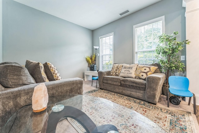 living area featuring carpet flooring, visible vents, and baseboards
