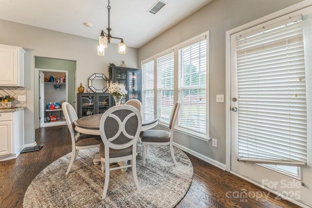 dining area with a healthy amount of sunlight, visible vents, and dark wood finished floors