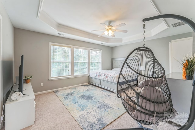 carpeted bedroom featuring baseboards, ceiling fan, a tray ceiling, and visible vents
