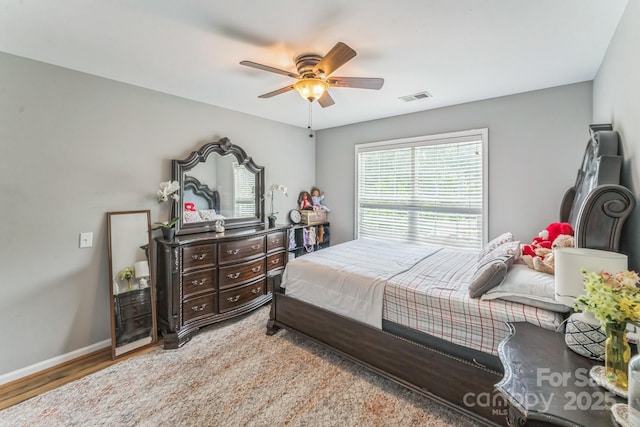 bedroom with baseboards, light wood-style flooring, visible vents, and a ceiling fan