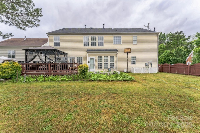 back of house featuring fence, a gazebo, and a lawn