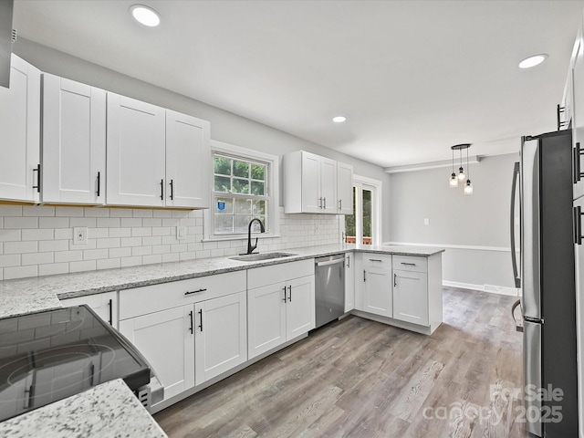 2544 Cedarwild Rd, Charlotte, NC 28212 - kitchen featuring a peninsula, white cabinets, tasteful backsplash, a sink, and stainless steel appliances