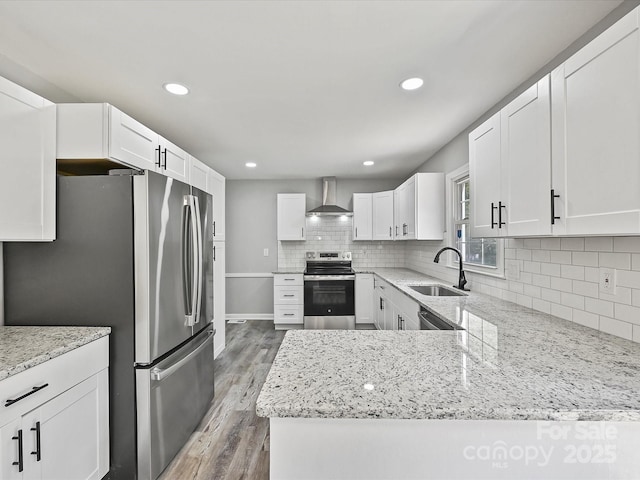 2544 Cedarwild Rd, Charlotte, NC 28212 - kitchen featuring appliances with stainless steel finishes, light stone counters, a sink, light wood-style flooring, and wall chimney exhaust hood