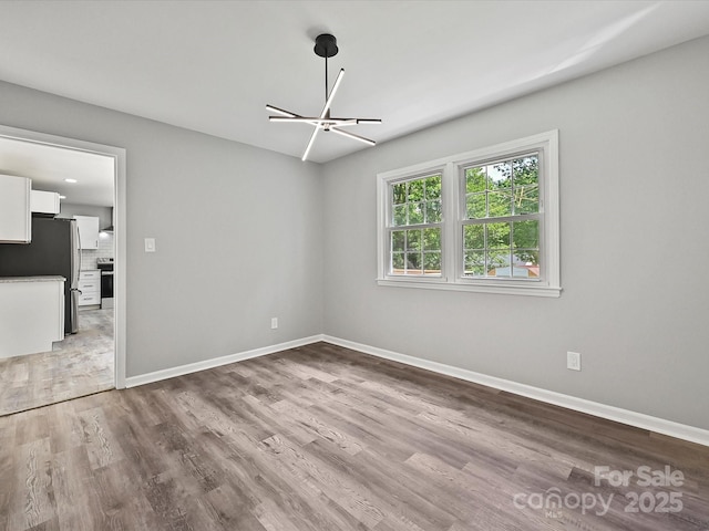 2544 Cedarwild Rd, Charlotte, NC 28212 - spare room with baseboards, an inviting chandelier, and wood finished floors