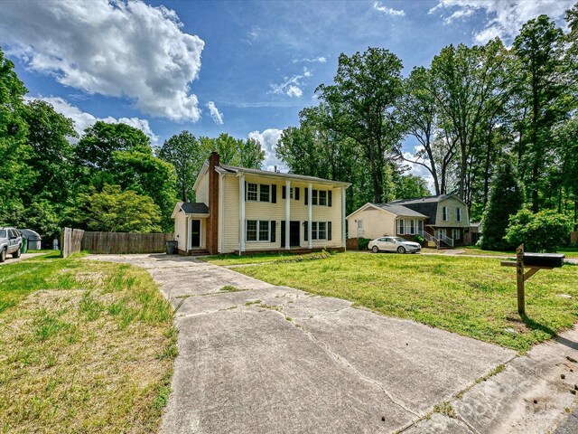 2544 Cedarwild Rd, Charlotte, NC 28212 - colonial home with fence, a front lawn, a chimney, covered porch, and driveway
