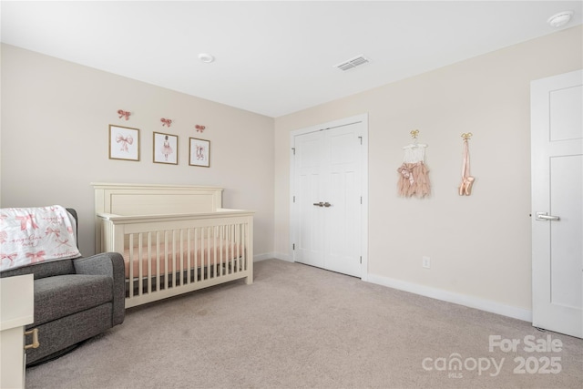 carpeted bedroom with baseboards, visible vents, and a crib