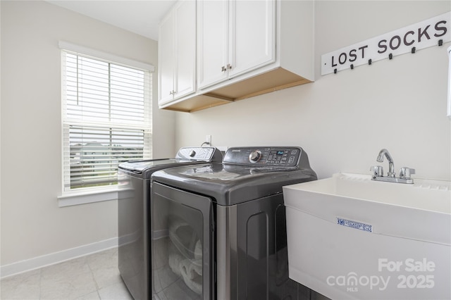 washroom featuring plenty of natural light, a sink, cabinet space, and washer and dryer