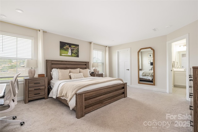bedroom featuring visible vents, connected bathroom, baseboards, and light carpet