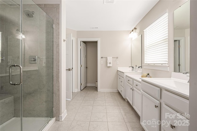 bathroom with a sink, a stall shower, and double vanity