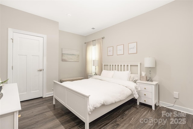 bedroom with baseboards and dark wood-type flooring