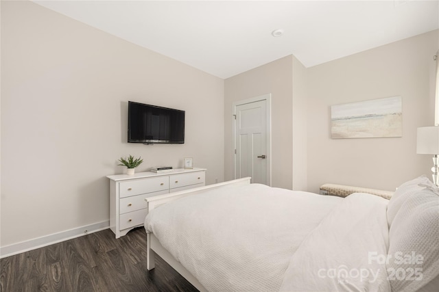 bedroom featuring baseboards and dark wood-type flooring