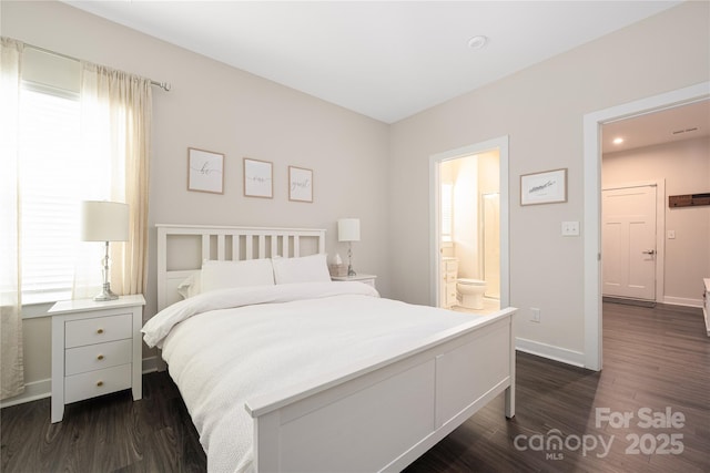 bedroom with recessed lighting, baseboards, dark wood finished floors, and ensuite bath