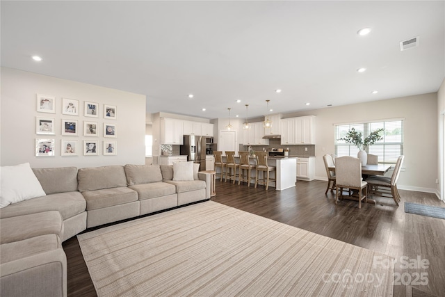 living room featuring dark wood-type flooring, recessed lighting, baseboards, and visible vents