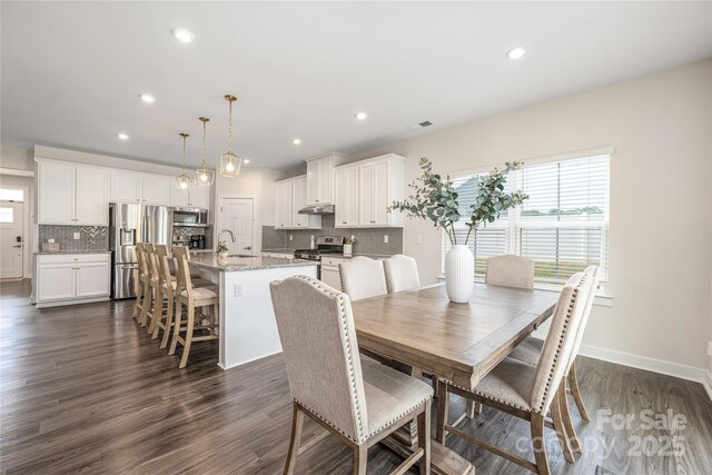 dining space with baseboards, dark wood-style flooring, and recessed lighting
