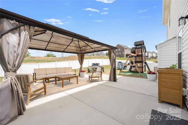 view of patio / terrace featuring a residential view, a gazebo, a fenced backyard, an outdoor hangout area, and a playground